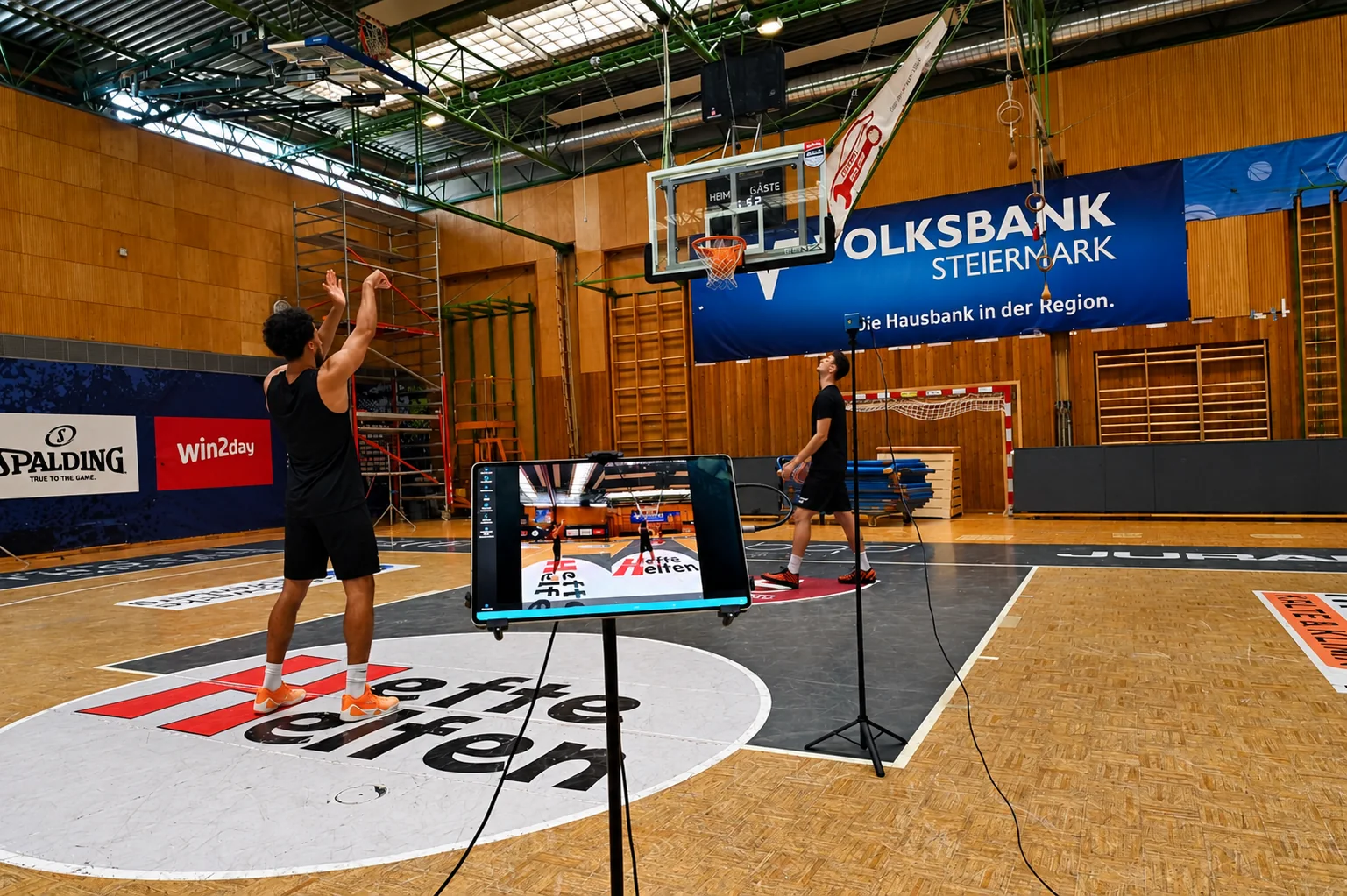 Wurftechnik-Analyse mit movAcam: Basketballspieler beim Wurf, Tablet mit Live-Analyse in der Halle